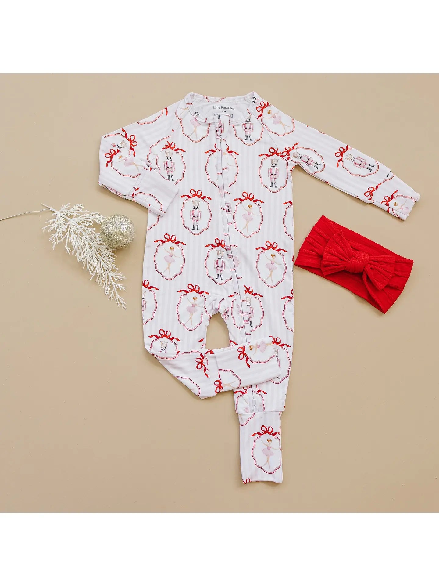 Baby romper with pink and red nutcracker christmas pattern.