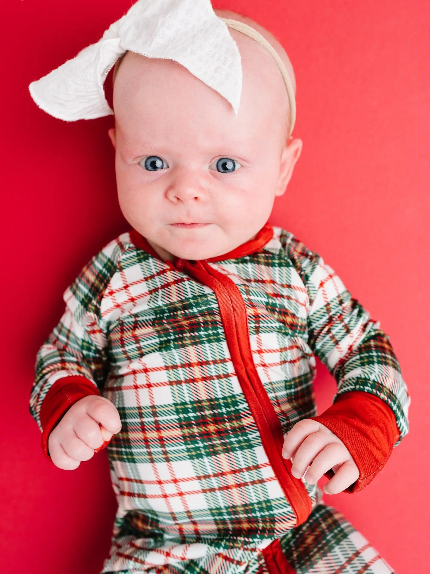 baby wearing classic christmas plaid bamboo sleeper with convertible hands and feet, and a 2-way zipper.