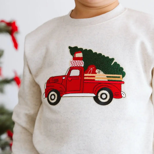 Toddler crew neck sweatshirt with patch of red truck carrying a christmas tree and presents.