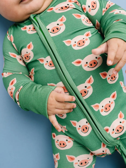 Green bamboo convertible sleeper with piglet pattern.